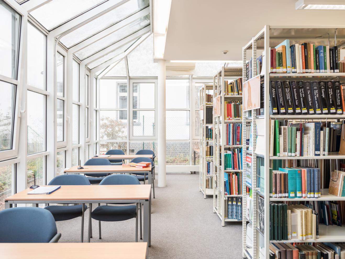 Bibliothek der HfMDK mit Arbeitsplätzen und Bücherregalen.