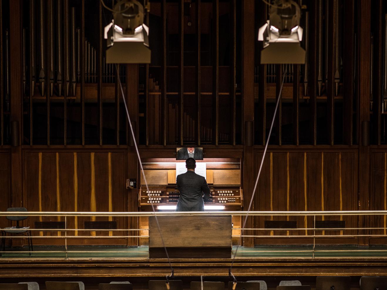 Ein Mann spielt an die Beckerath-Orgel im Großen Saal der Hochschule