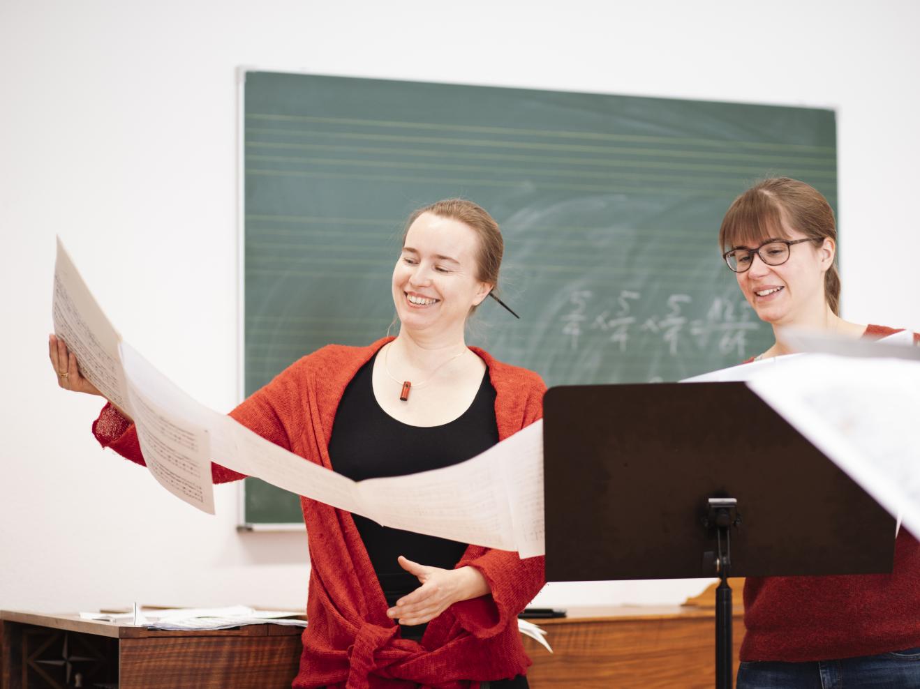 Professorin und Studentin mit einer sehr großen Partitur