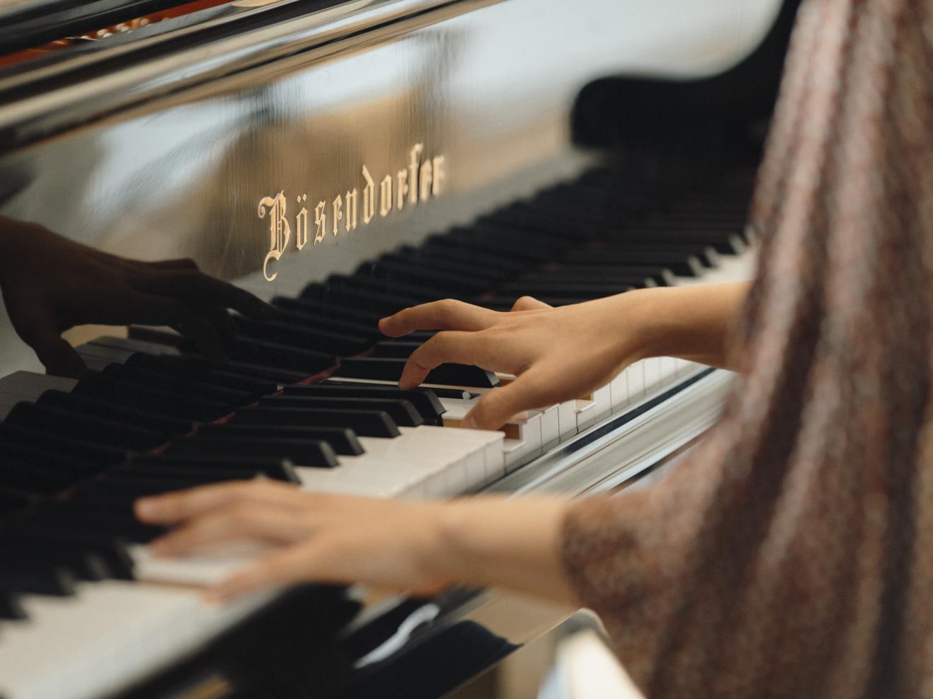 Nahaufnahme von Händen, die Klavier spielen.