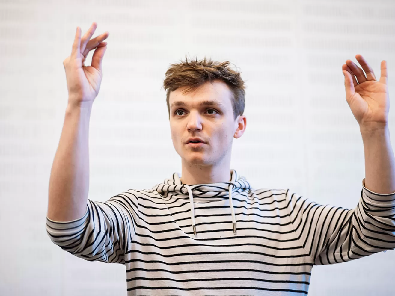 Student dirigiert mit erhobenen Armen