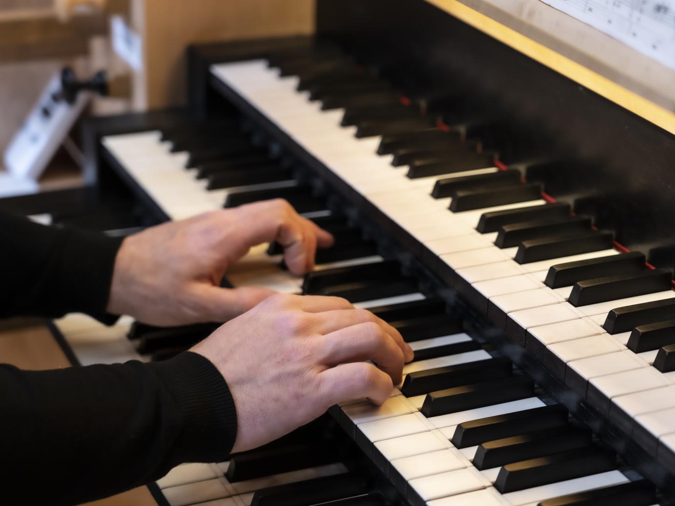 Hände auf den Tasten der Kern-Orgel