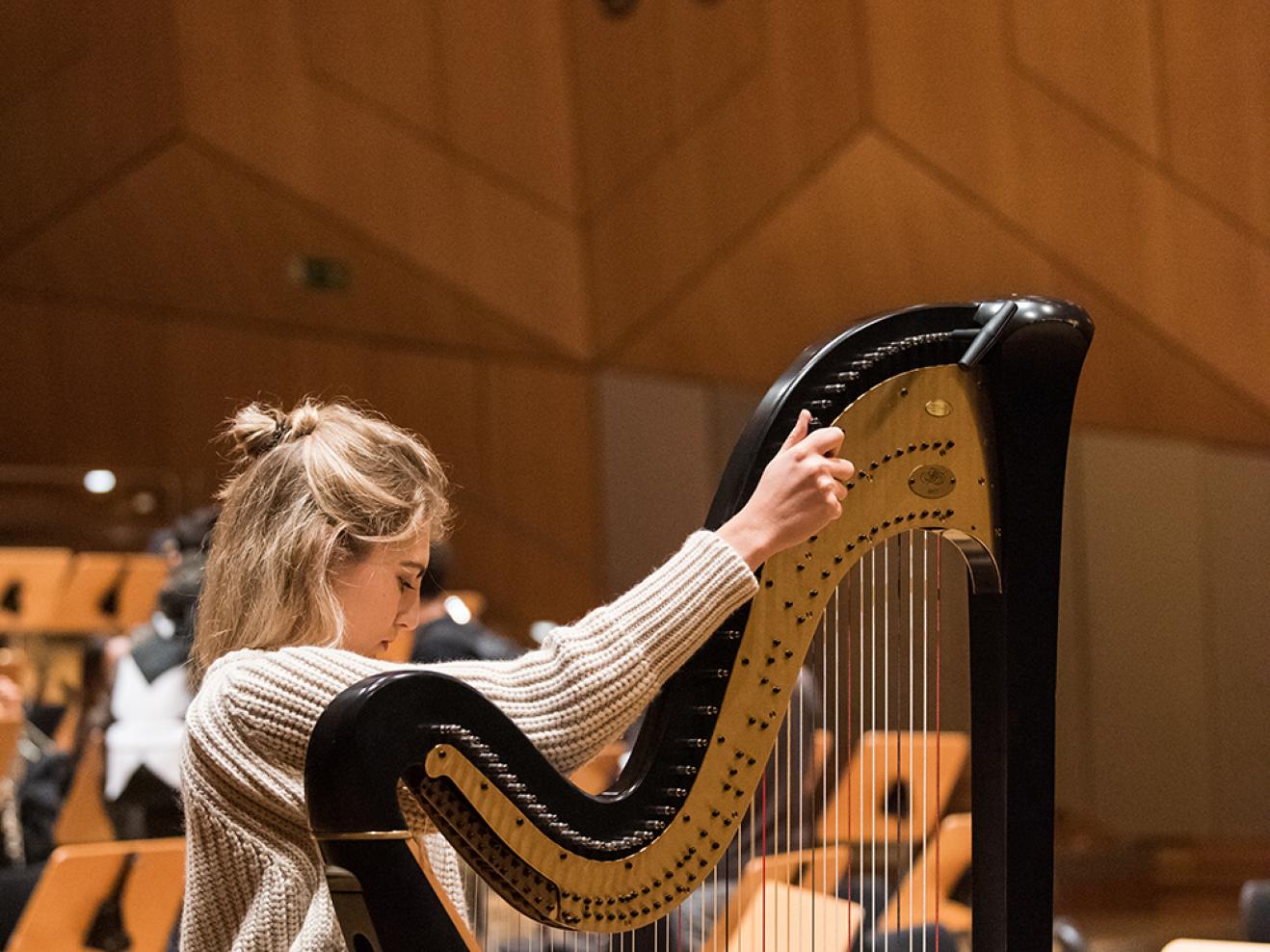 Musikerin stimmt die Harfe