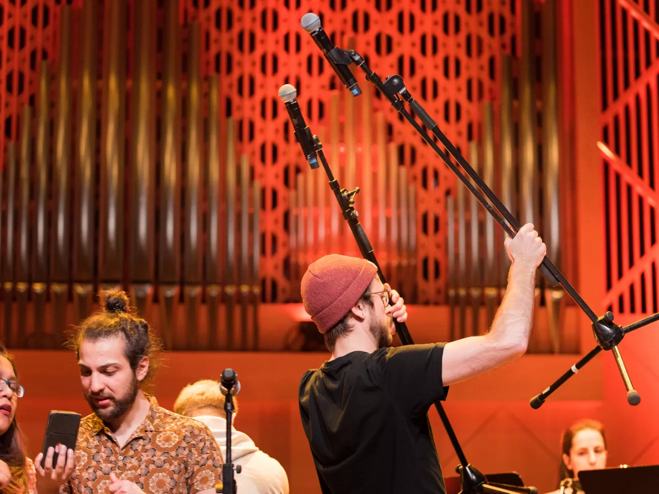 Eine Person trägt zwei Mikrofone auf Mikrofonständern