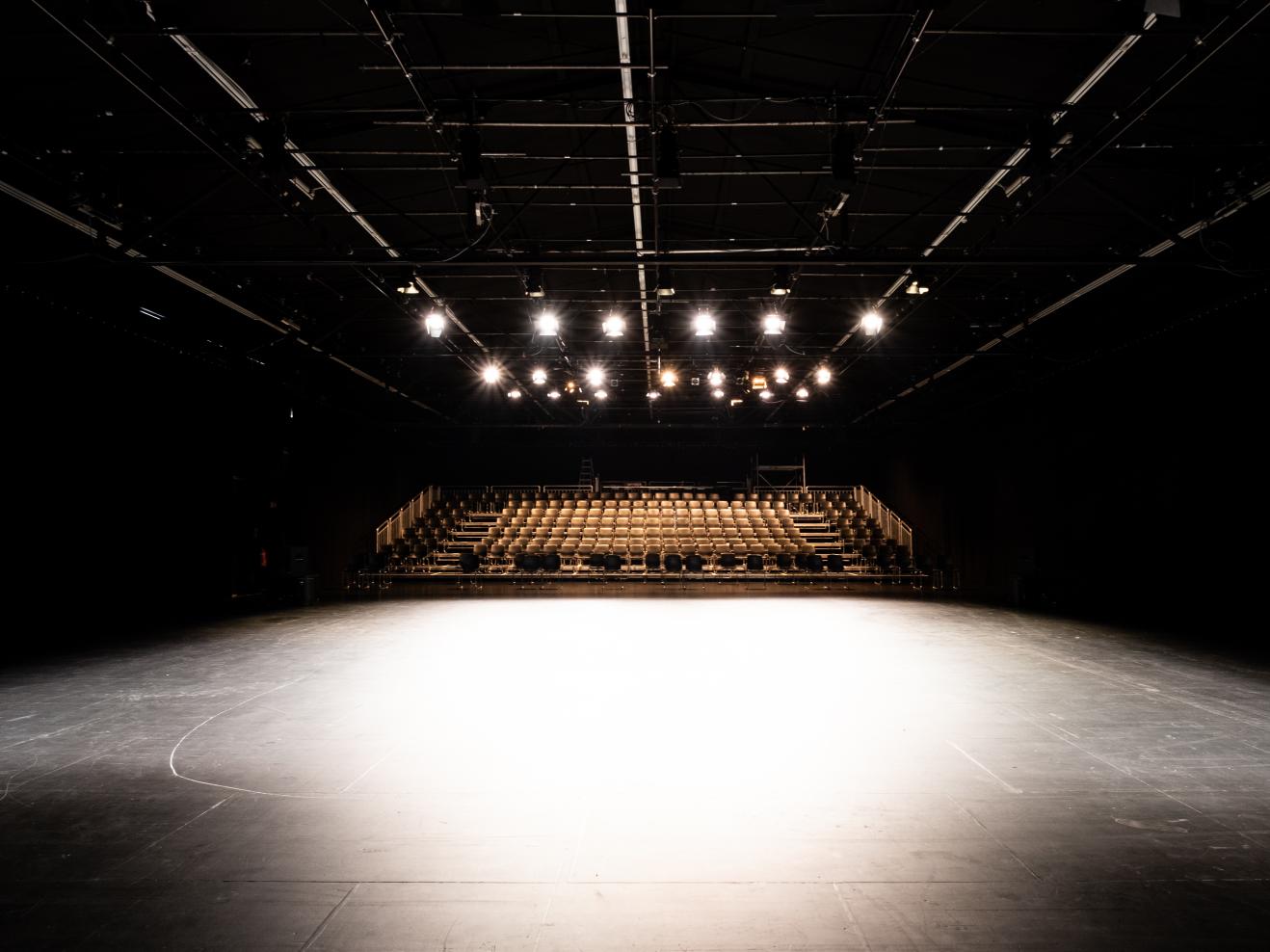 Leere Bühne der Halle 1 im Frankfurt LAB im Scheinwerferlicht, Blick auf die Sitze für das Publikum.