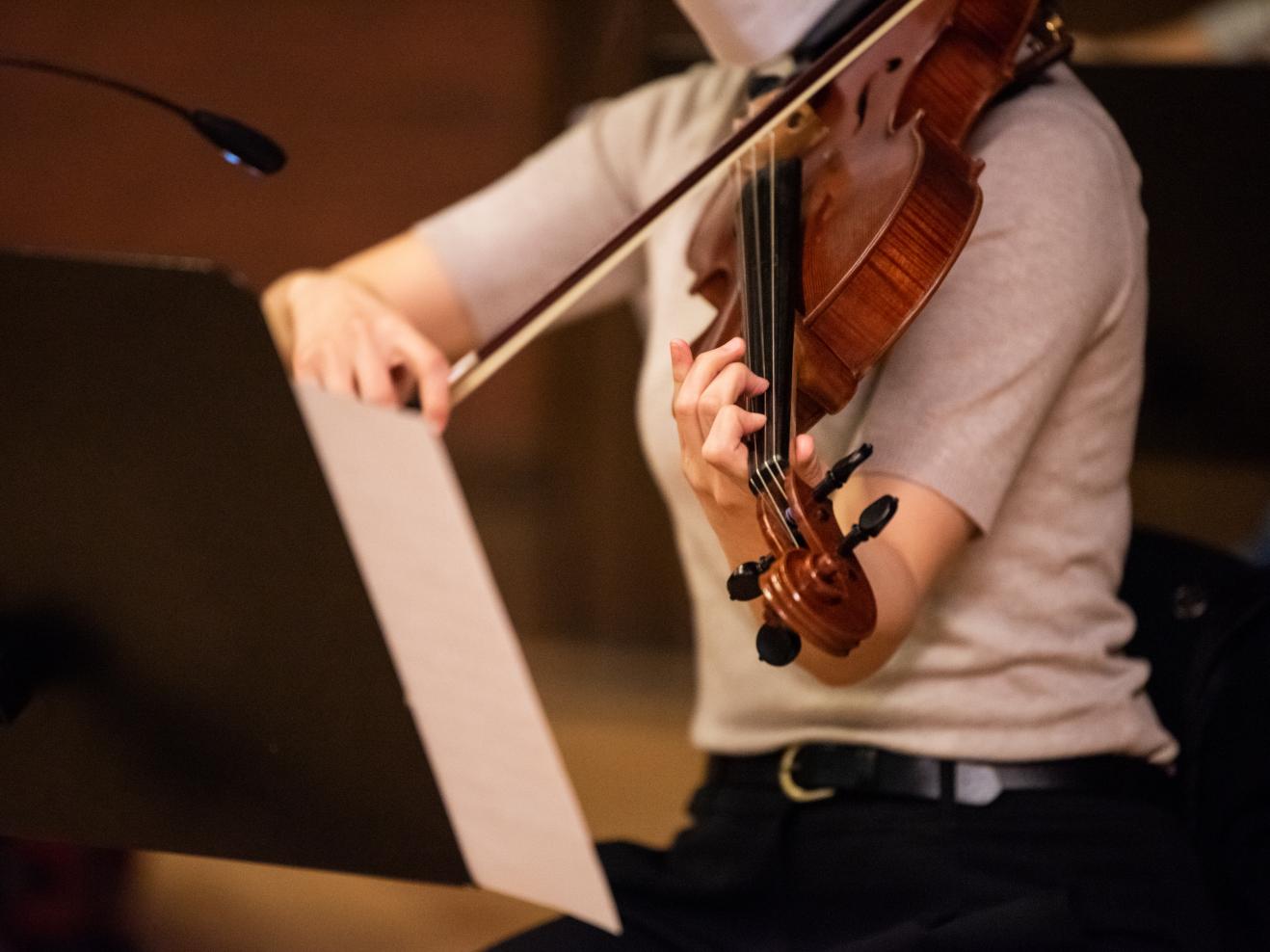 Detailaufnahme einer Hand auf dem Griffbrett einer Viola