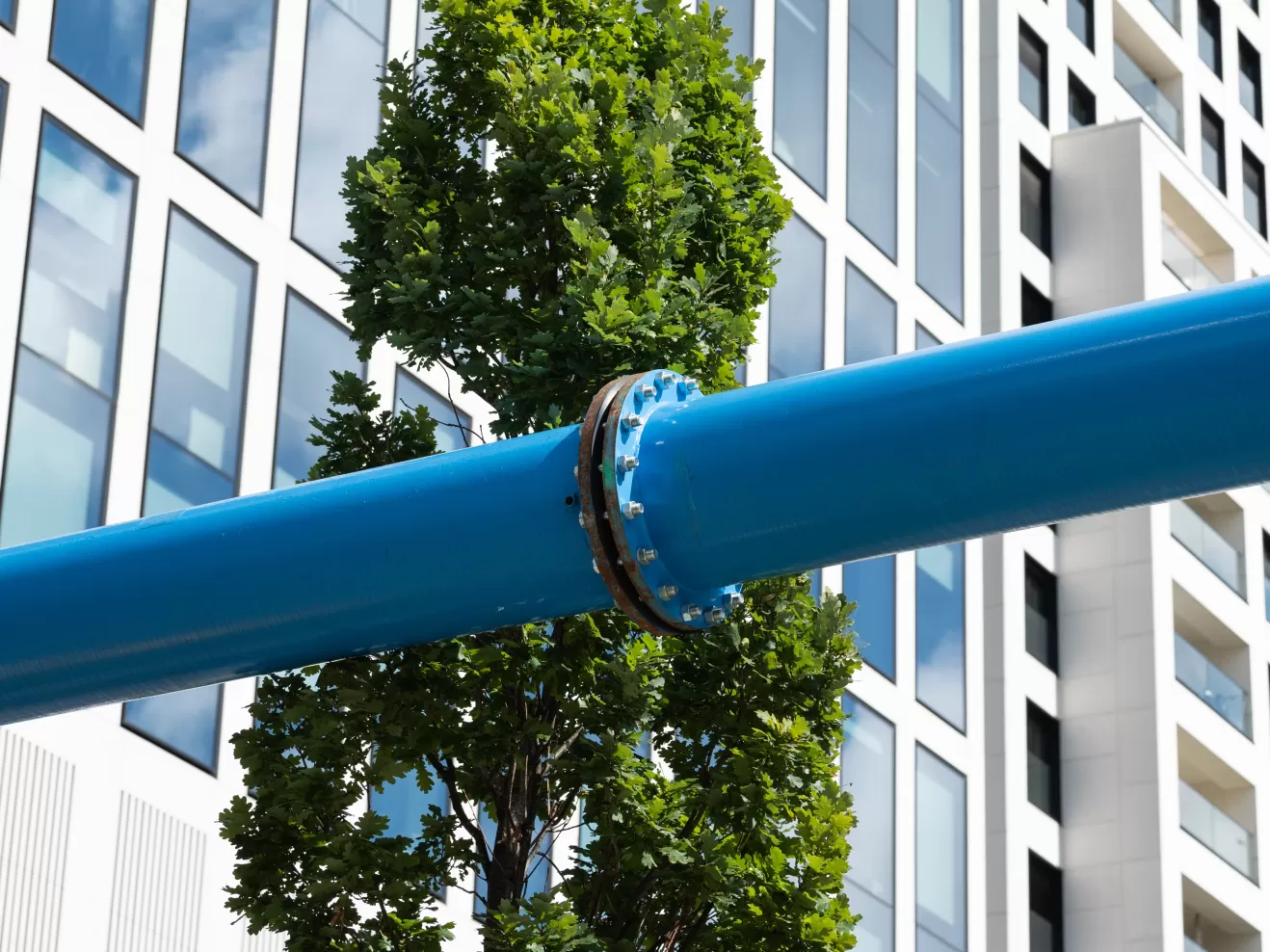 Fassaden in Frankfurt, ein blaues Baustellenrohr läuft durchs quer durchs Bild.