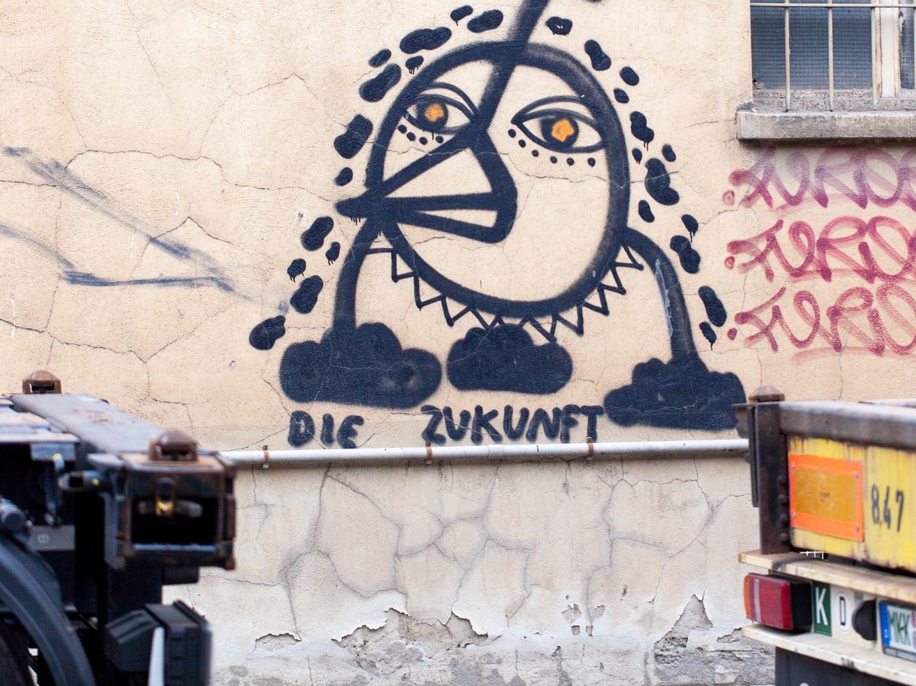 Graffiti an einer Hauswand: Ein Fabelwesen und der Text "Die Zukunft"