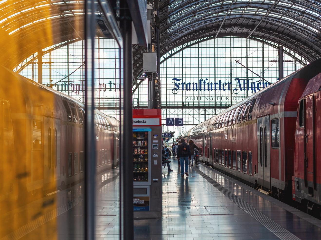 Am Frankfurter Hauptbahnhof steht ein Zug am Gleis 5, Personen steigen ein und aus.