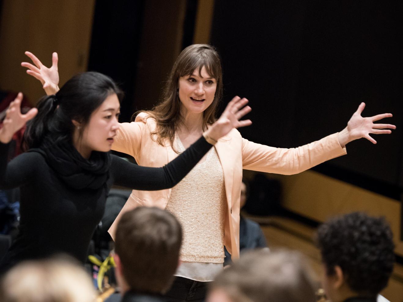 Prof. Katharina Deserno und eine Studentin leiten ein Kinderorchester.