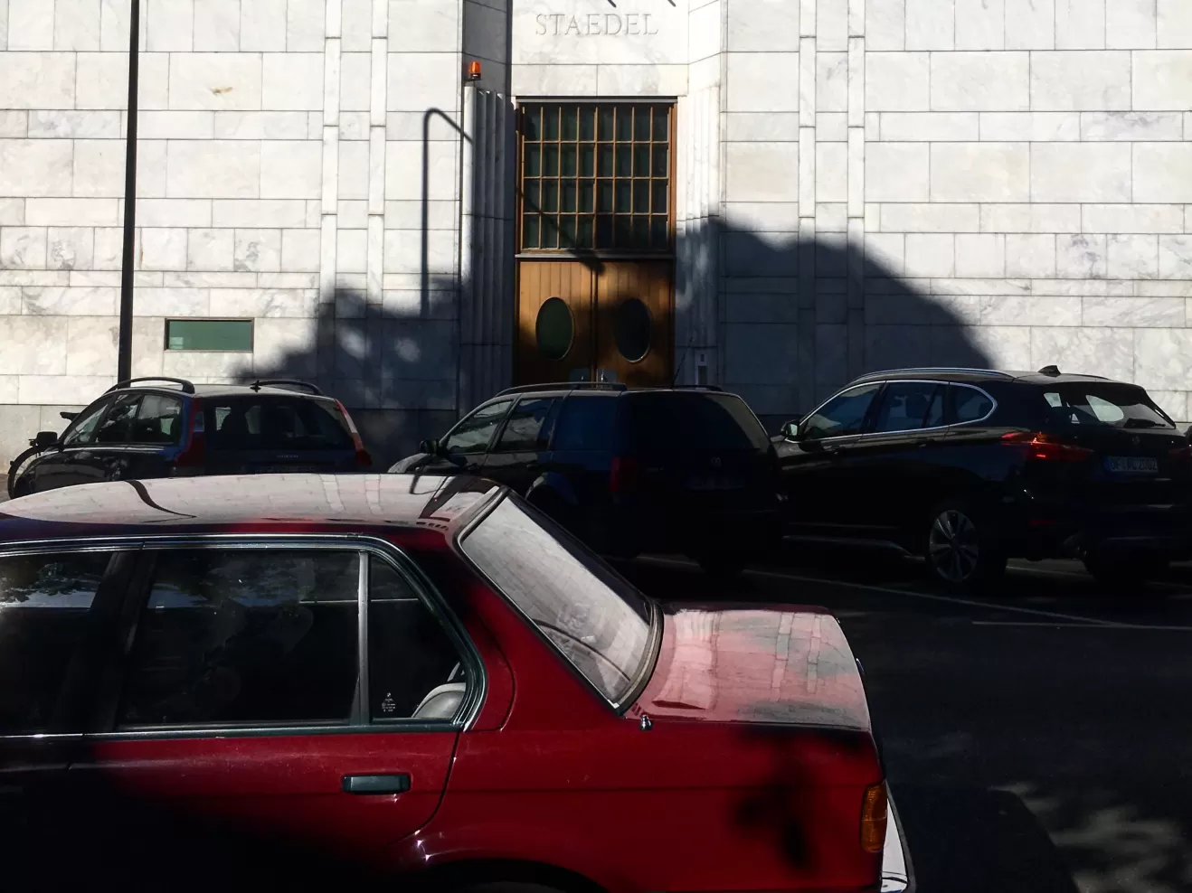 Ein rotes Auto parkt vor dem Hintereingang des Städel Museums