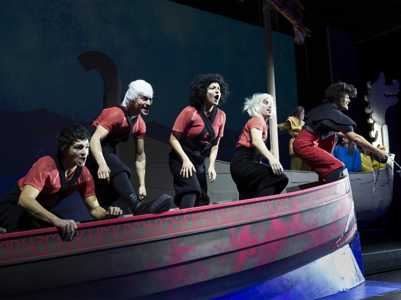 Fünf Schauspieler*innen stehen rufend auf einem Wikingerschiff.