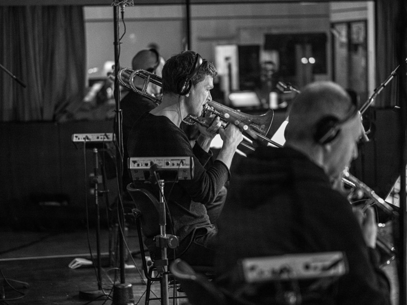 Posaunist der hr-Bigband bei einer Aufnahme, er spielt sein Instrument und trägt Kopfhörer.