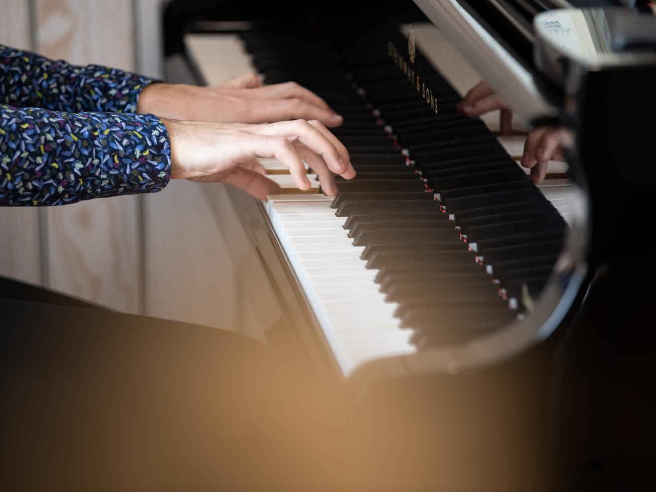 Nahaufnahme der Hände eines Pianisten am Klavier