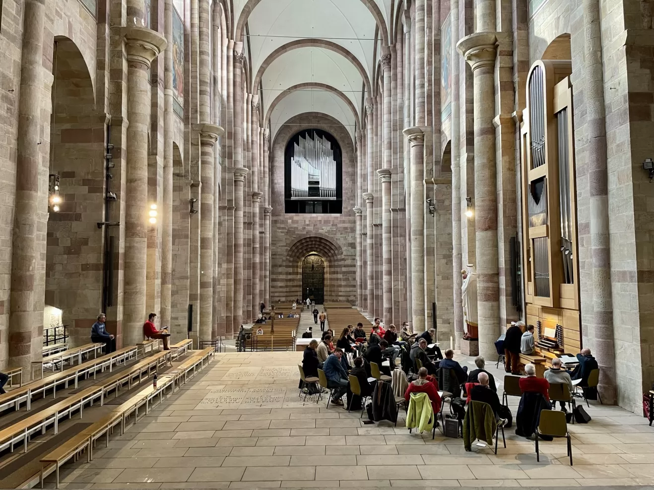 Blick vom Altar in den Dom, rechts die Chororgel mit den Kursteilnehmenden, die einer Unterrichtseinheit folgen