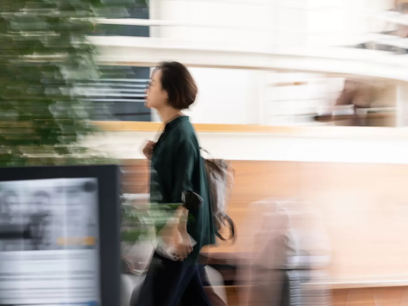 Eine Person geht durch das Foyer der HfMDK, mit langer Belichtungszeit ist die Bewegung künstlerisch verwischt.