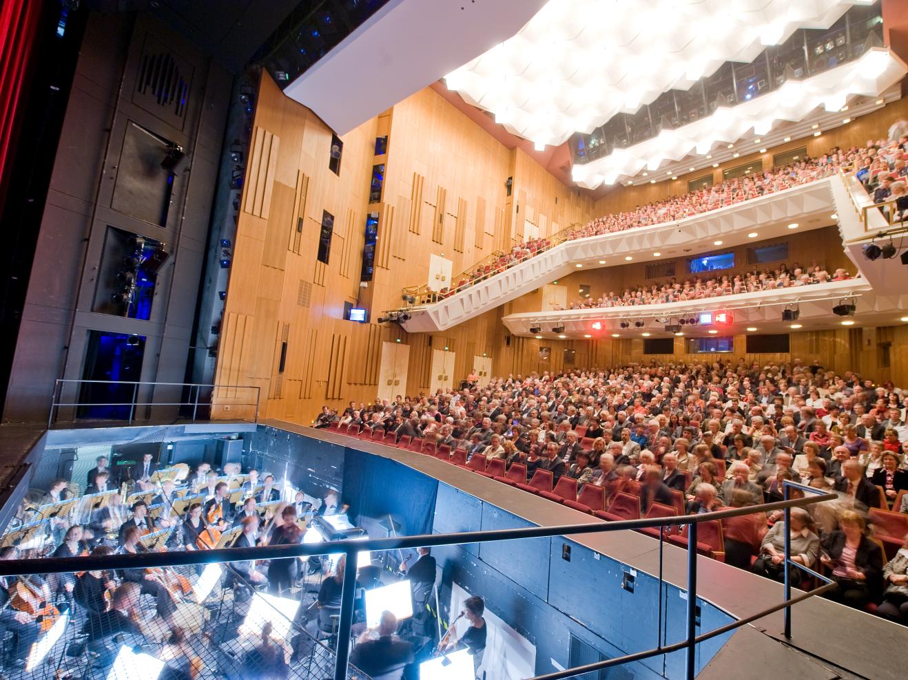 Theatersaal mit Publikum und Musiker*innen im Orchestergraben