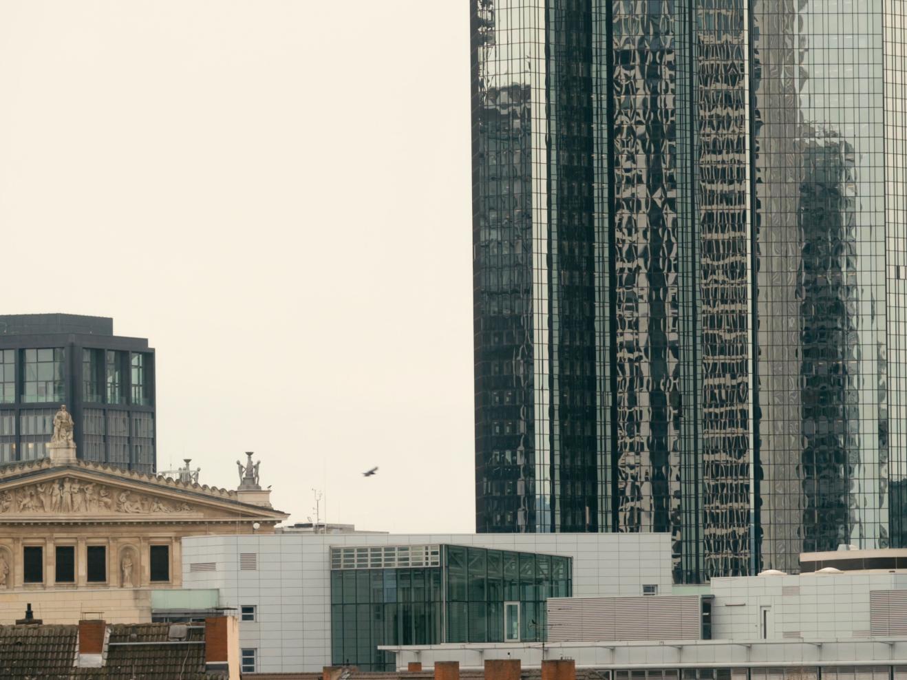 Ausschnitt des Ausblicks auf die Skyline von Frankfurt. Links ist das markante Dach der Alten Oper zu sehen, rechts Hochhäuser des Bankenviertels.