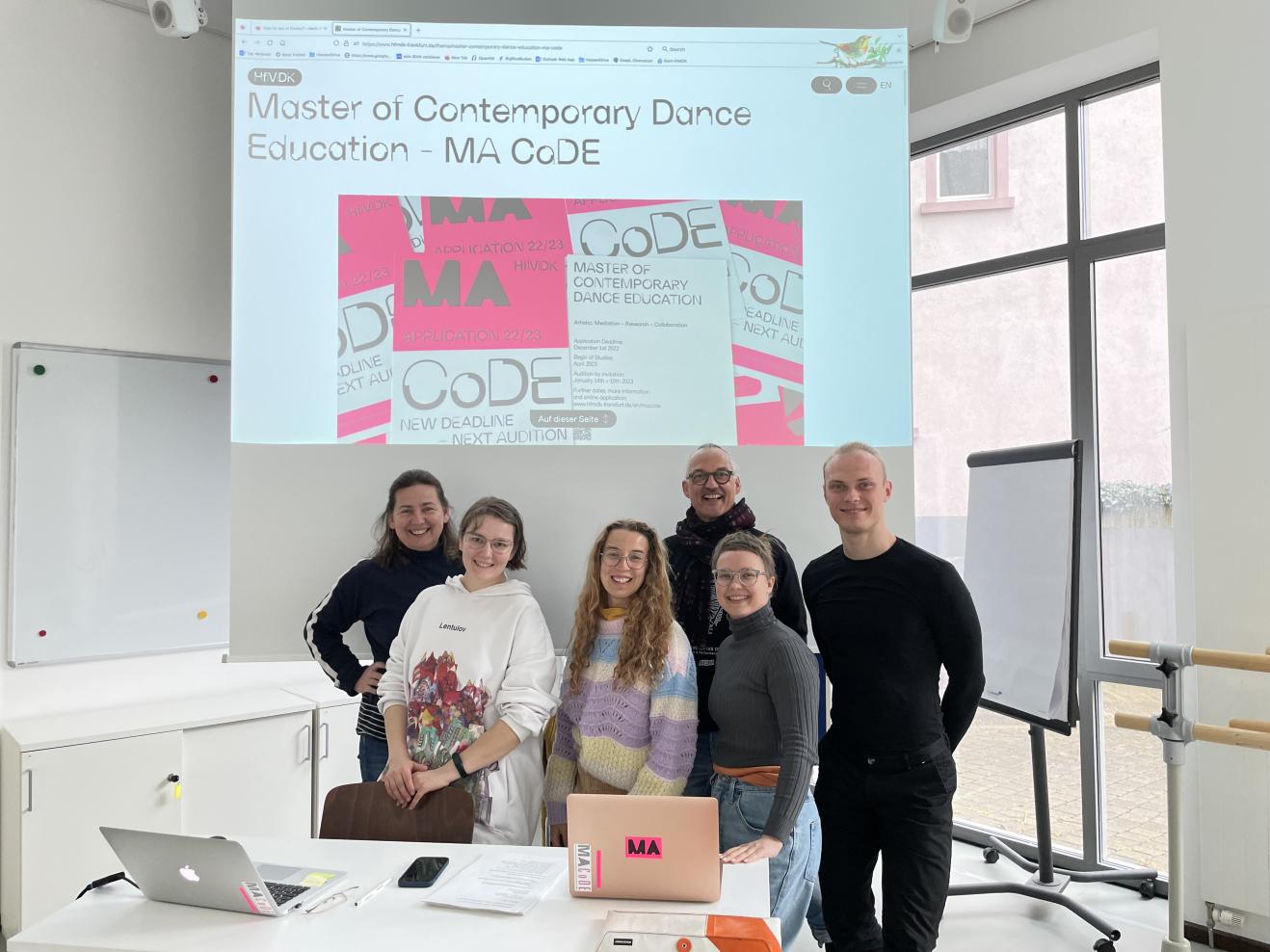 Die neuen Studierenden von MA CoDE vor einer Leinwand, zusammen mit Ingo Diehl und Susanne Triebel