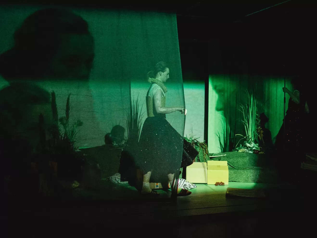 Eine Schauspielerin zieht einen Bühnenvorhang zu.