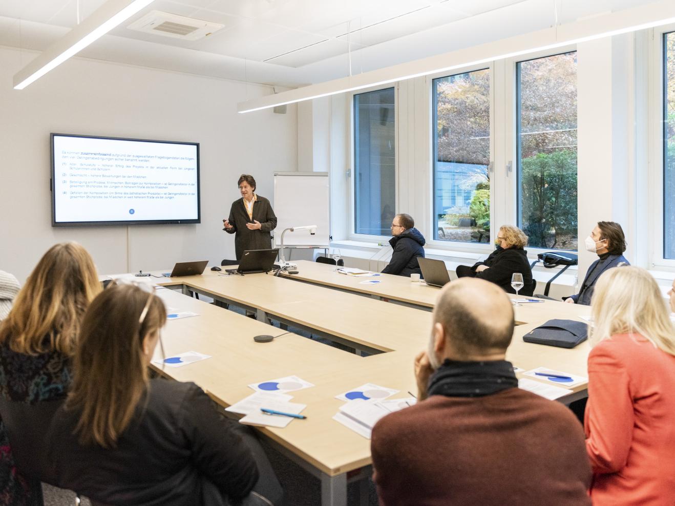 Präsentation von Prof. Dr. Maria Spychiger beim Tag der Forschung. Um den Tisch sitzen etwa 10 zuhörende Personen