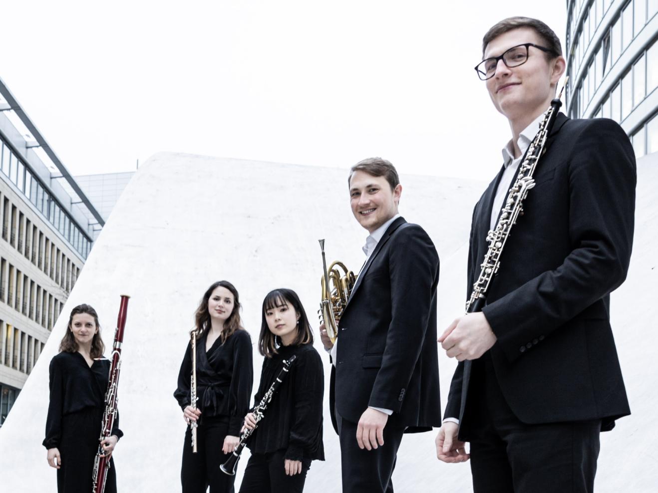 Gruppenfoto eines Bläserquintetts mit Instrumenten