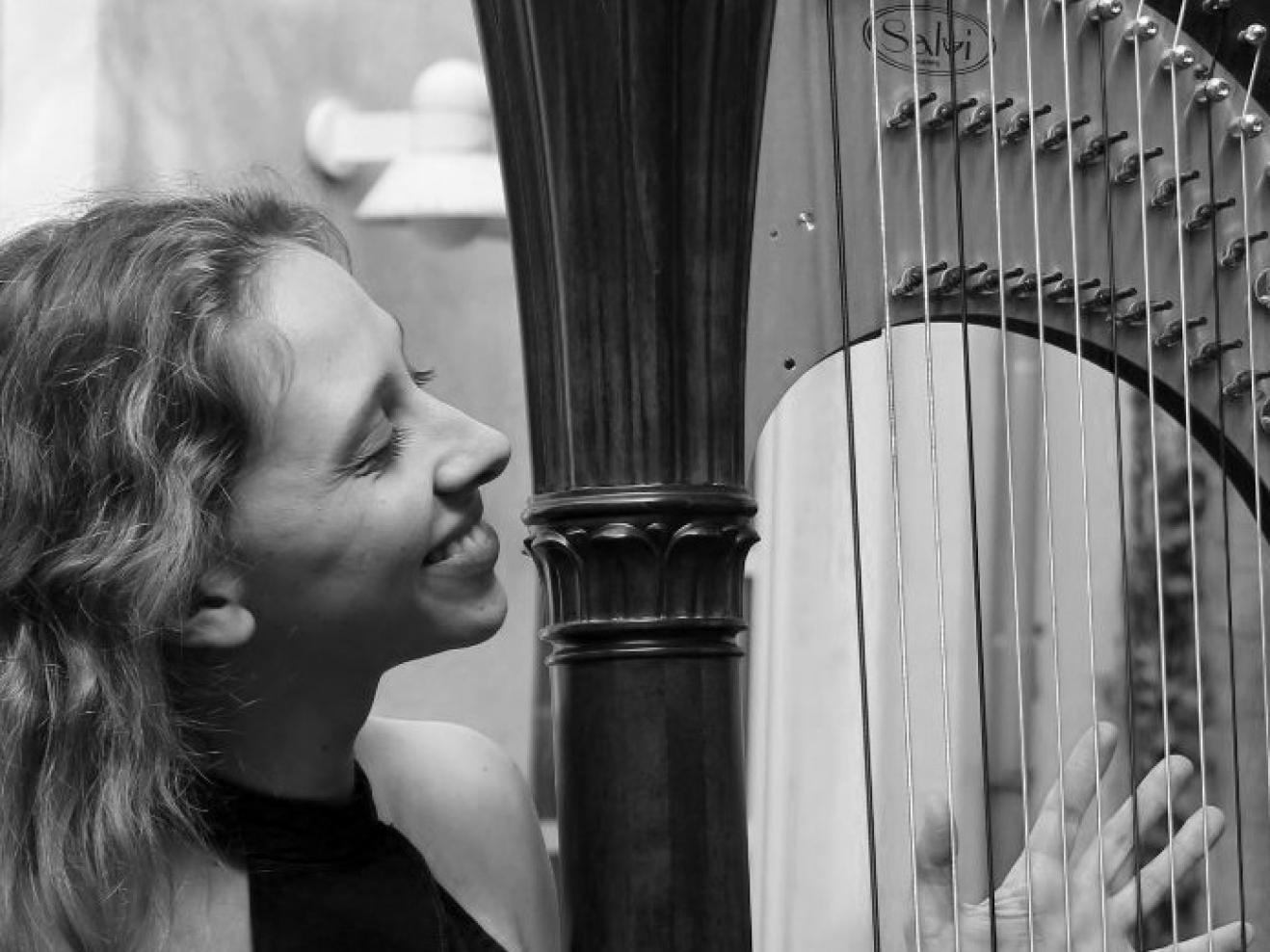 Schwarz-weiß Bild einer Harfenistin mit ihrem Instrument