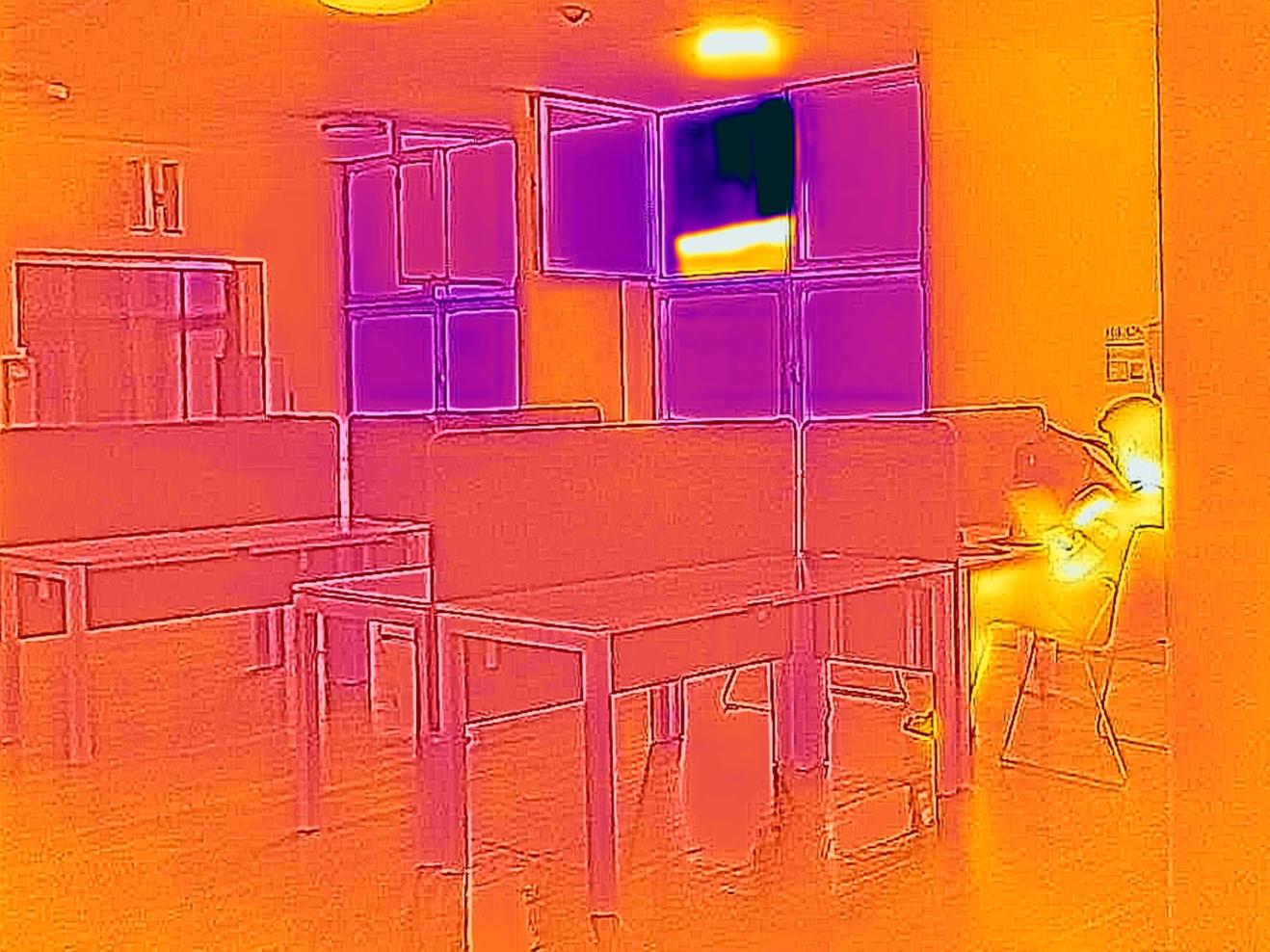 Thermografie-Aufnahme im Treppenhaus der HfMDK mit Arbeitsplätzen und einem offenen Fenster.