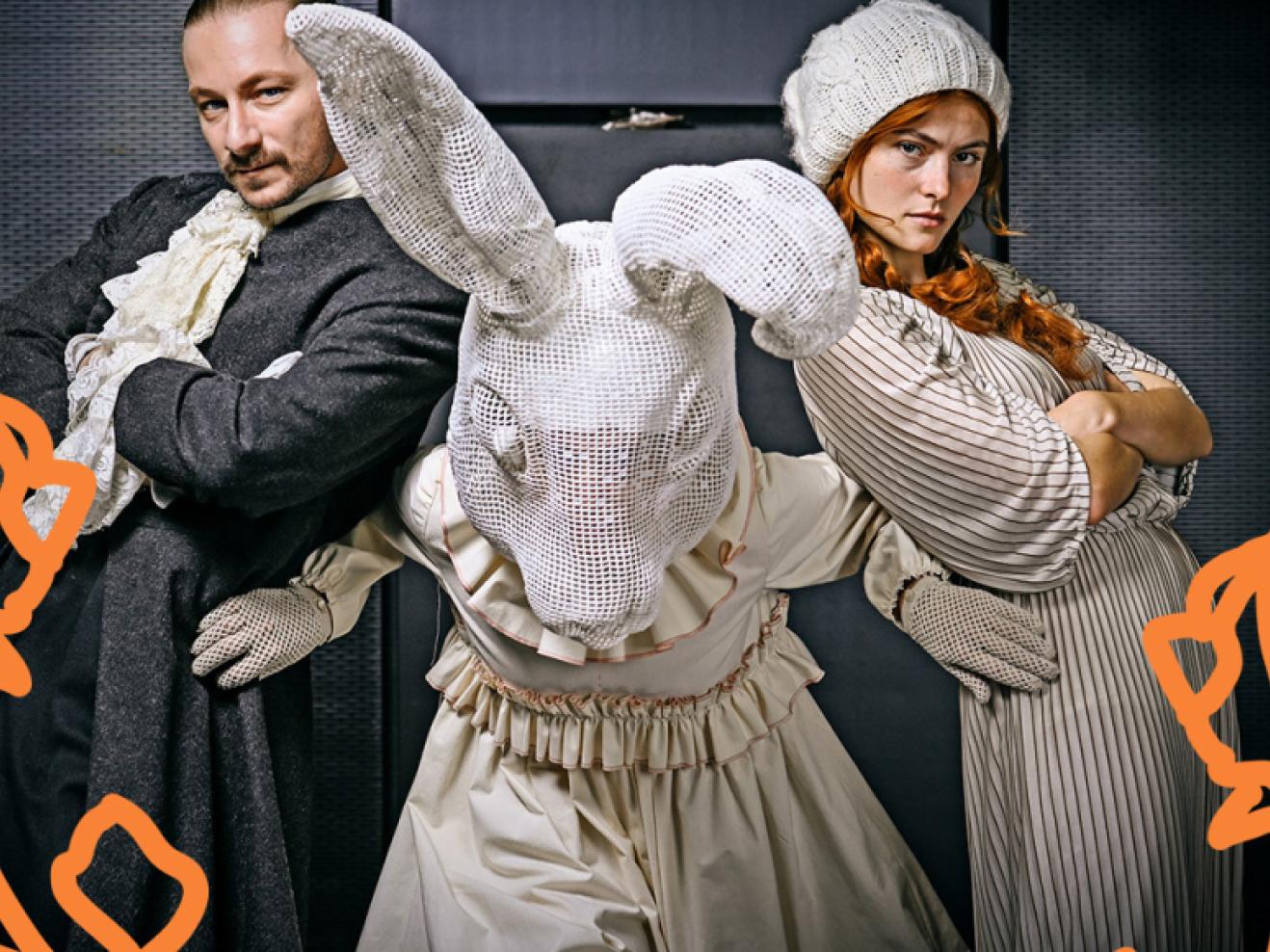 Ein Mann und eine Frau mit verschränkten Armen, zwischen ihnen ein großer Hase.
