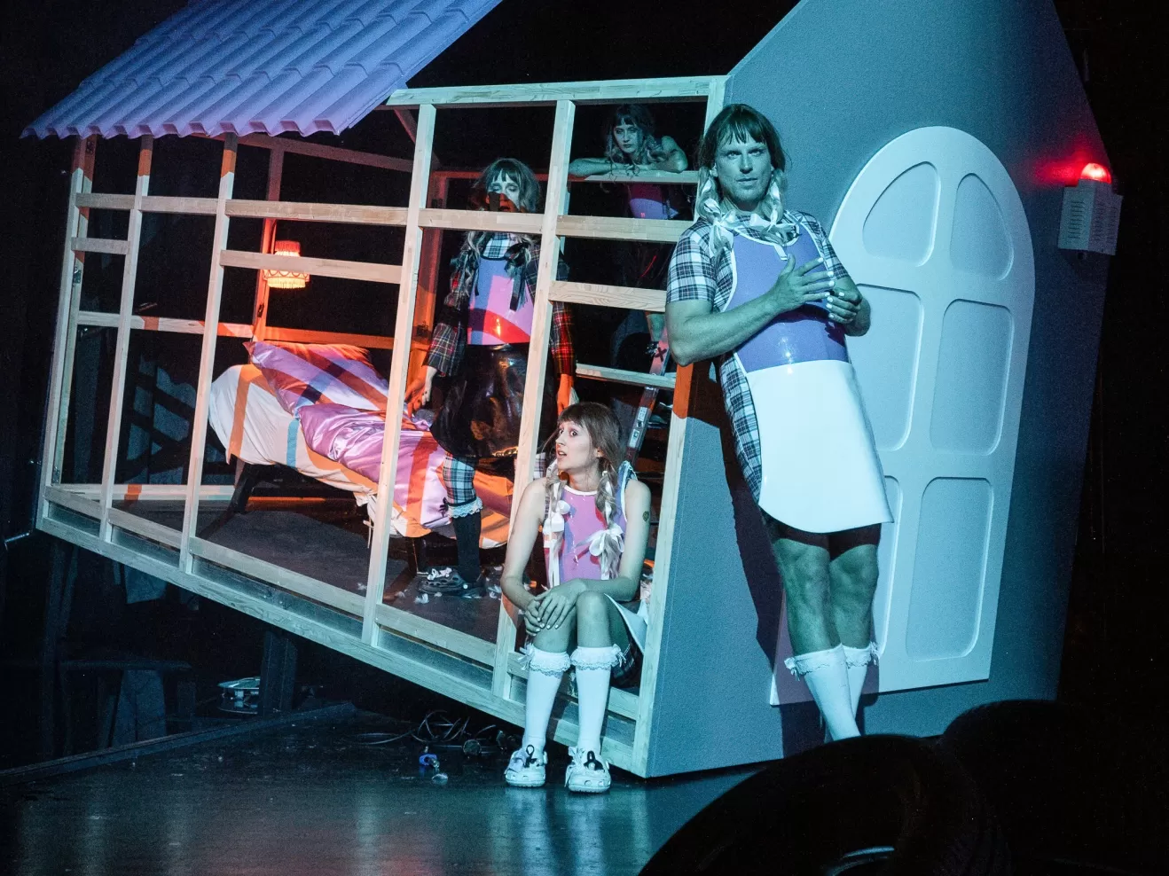 Mehrere Personen sitzend und stehend in einer Hausfassade.