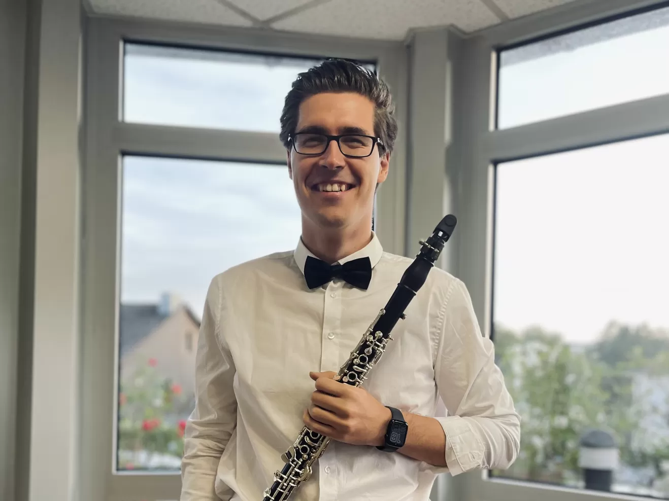 Person mit Klarinette lächelt in die Kamera