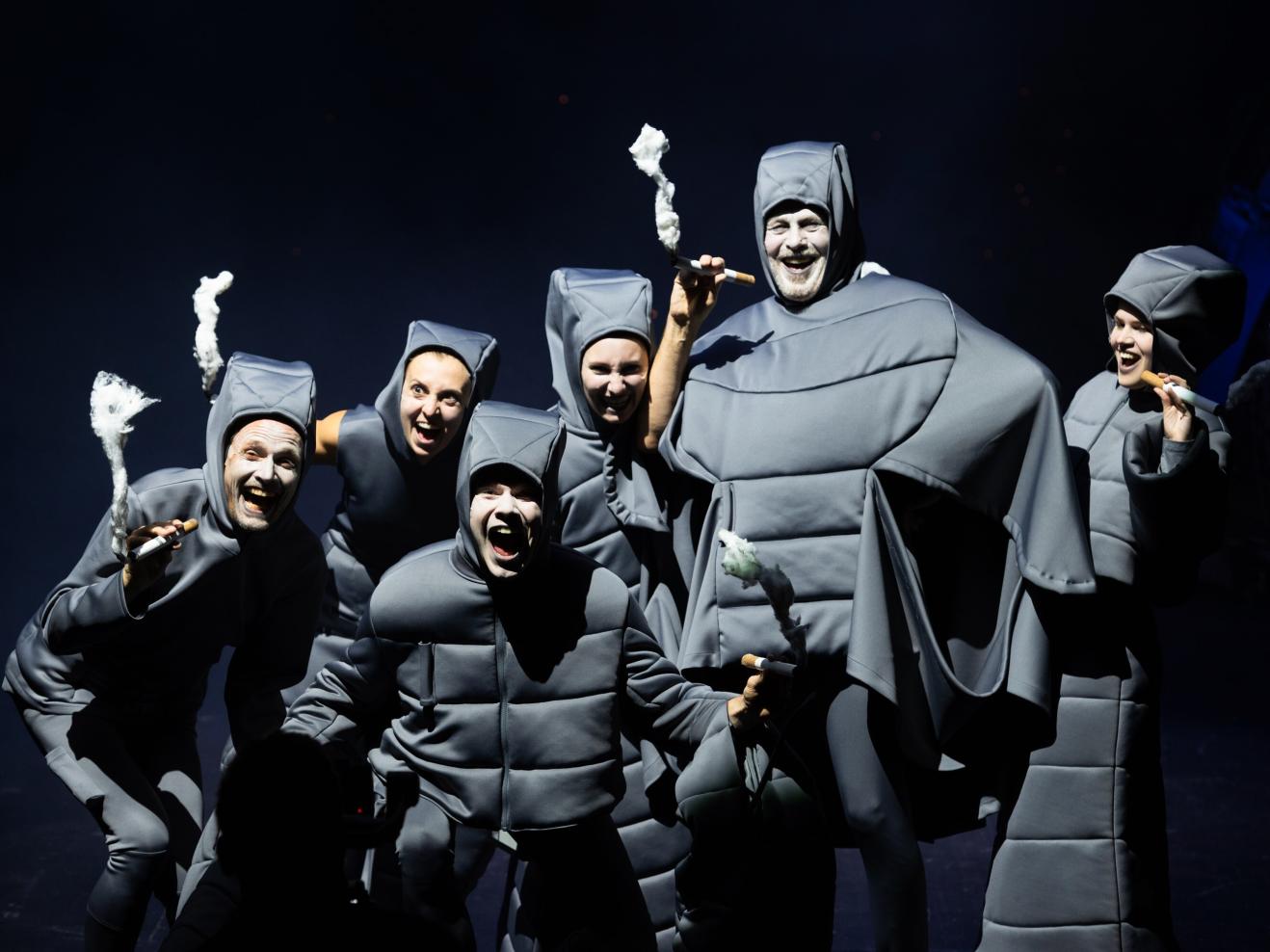 Gruppe schwarz gekleidetet und rauchender Personen.