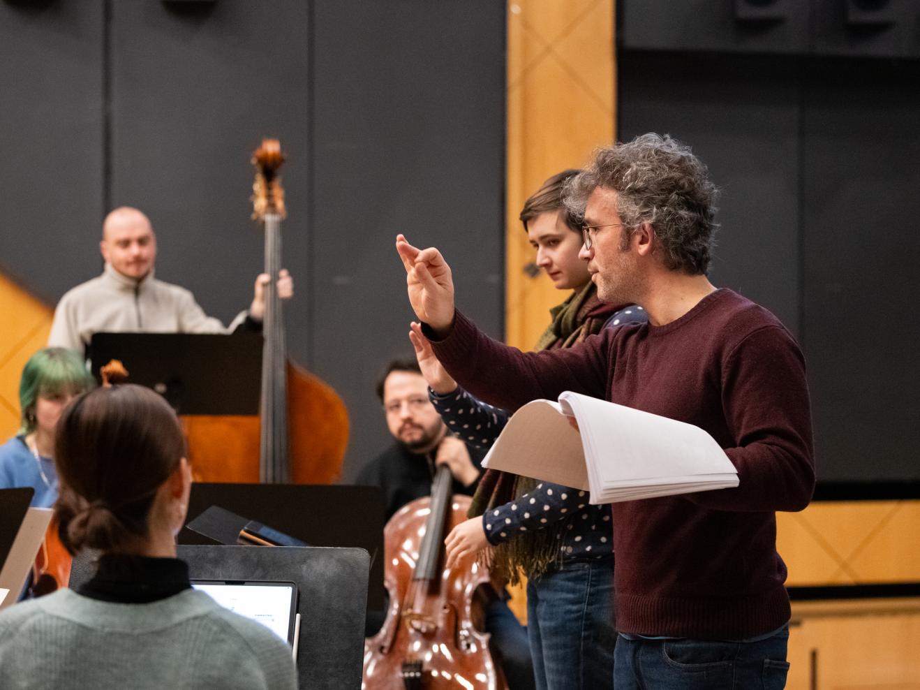 Christoph Altstaedt unterrichtet eine Studentin vor dem Ensemble im Dirigieren