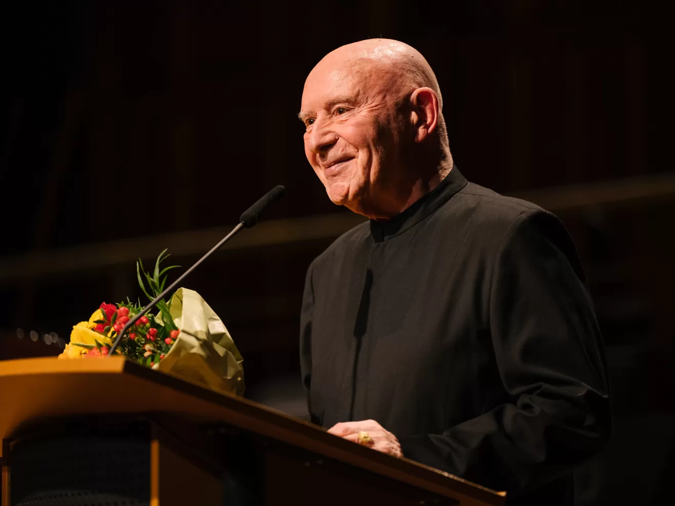 Christoph Eschenbach am Rednerpult mit einem Blumenstrauss