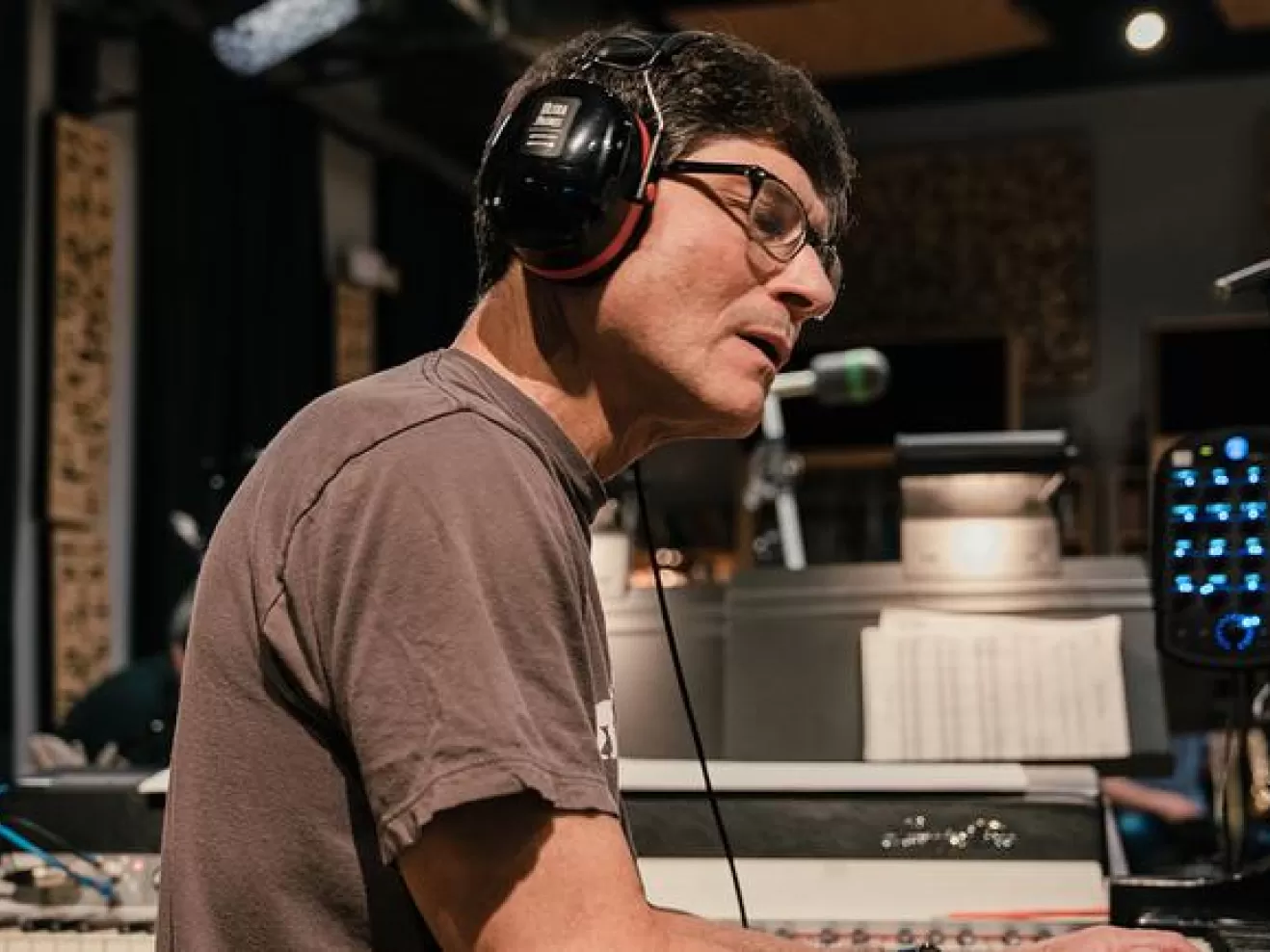 Mike Holober sitzt am Klavier und spielt. Er trägt Kopfhörer und hat die Augen geschlossen.