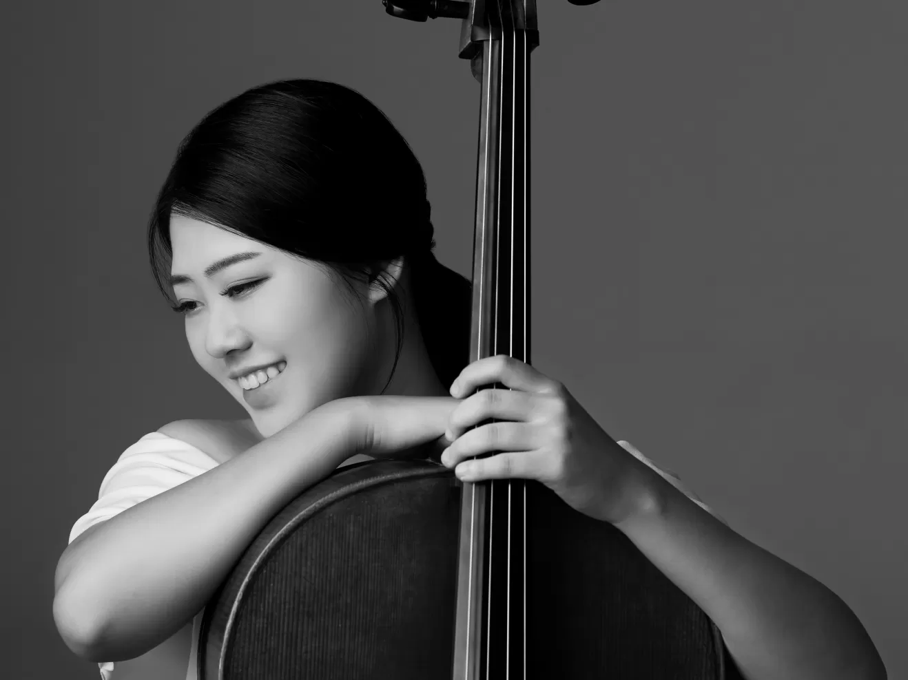 Ein Portraitfoto von Sebin Lee mit ihrem Cello in schwarz/weiß.