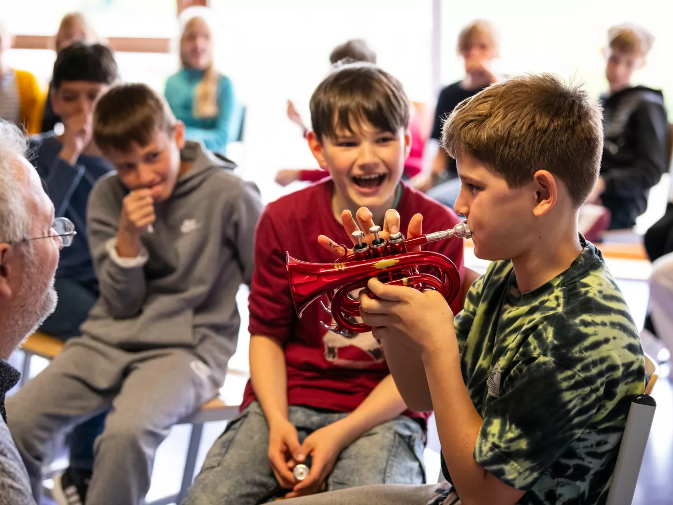 Ein Schüler probiert eine kleine rote Trompete aus.