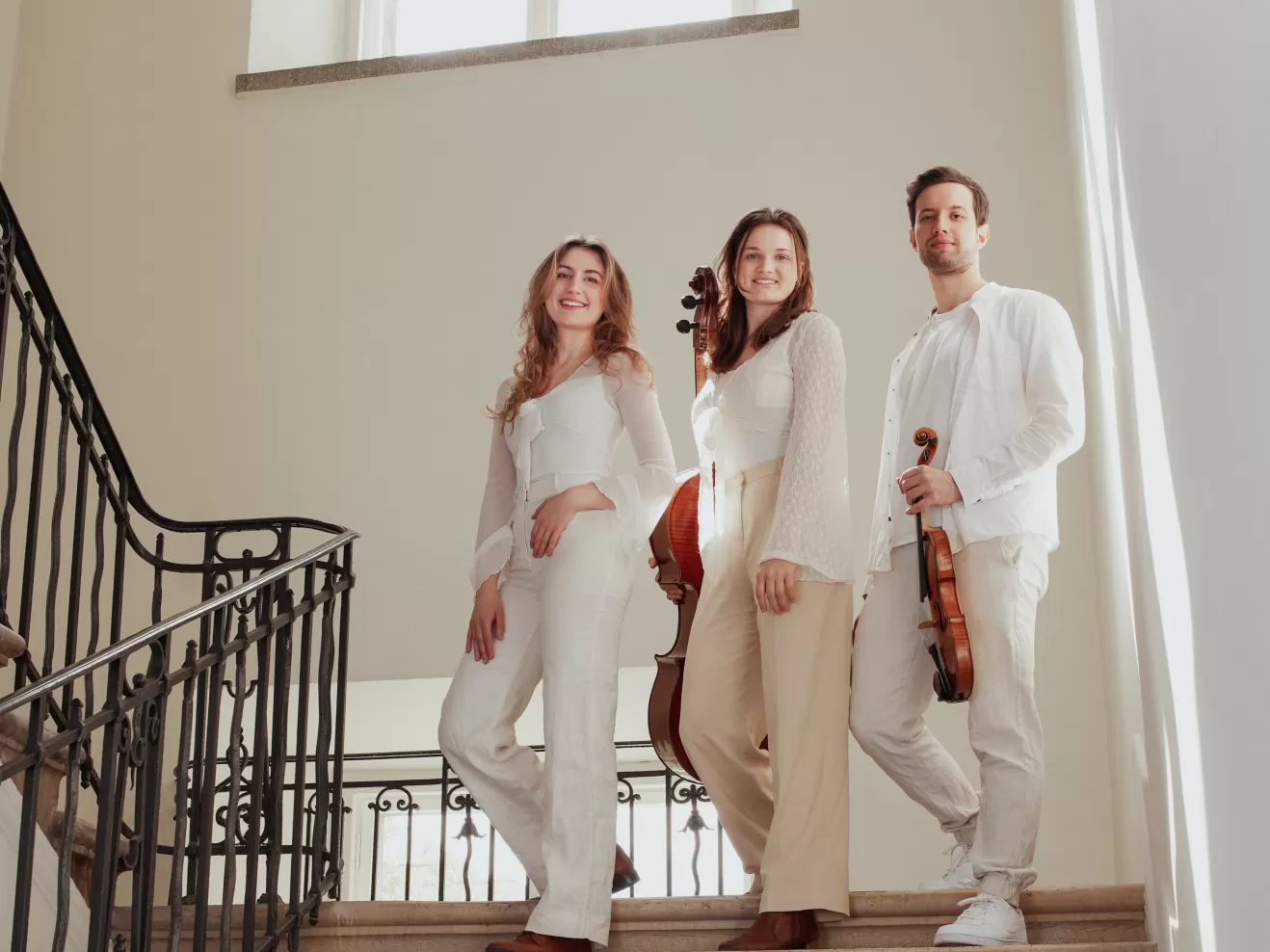 Die drei Musiker*innen des Bernstein Trios stehen auf einer Treppe.