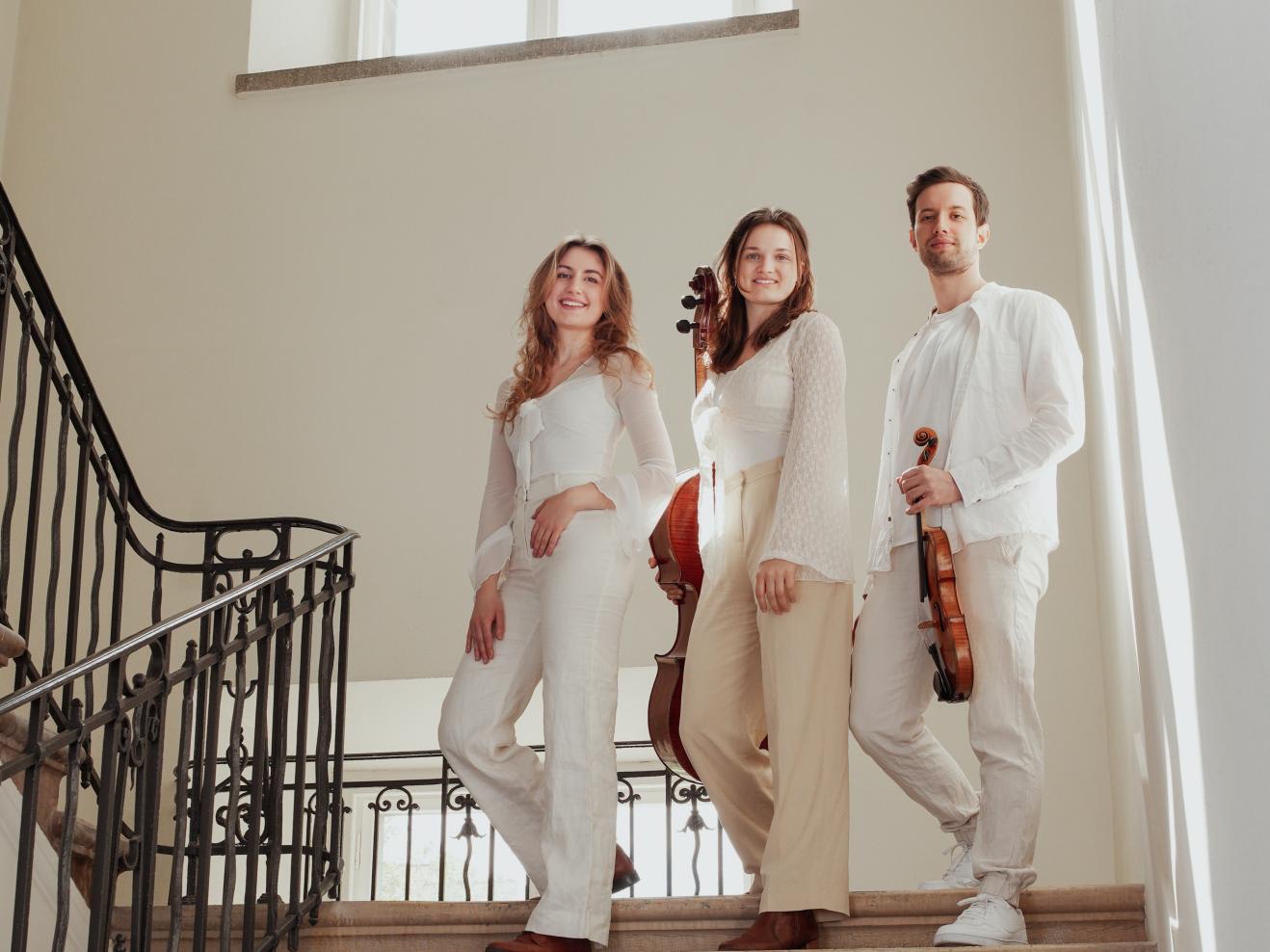 Die drei Musiker*innen des Bernstein Trios stehen auf einer Treppe.