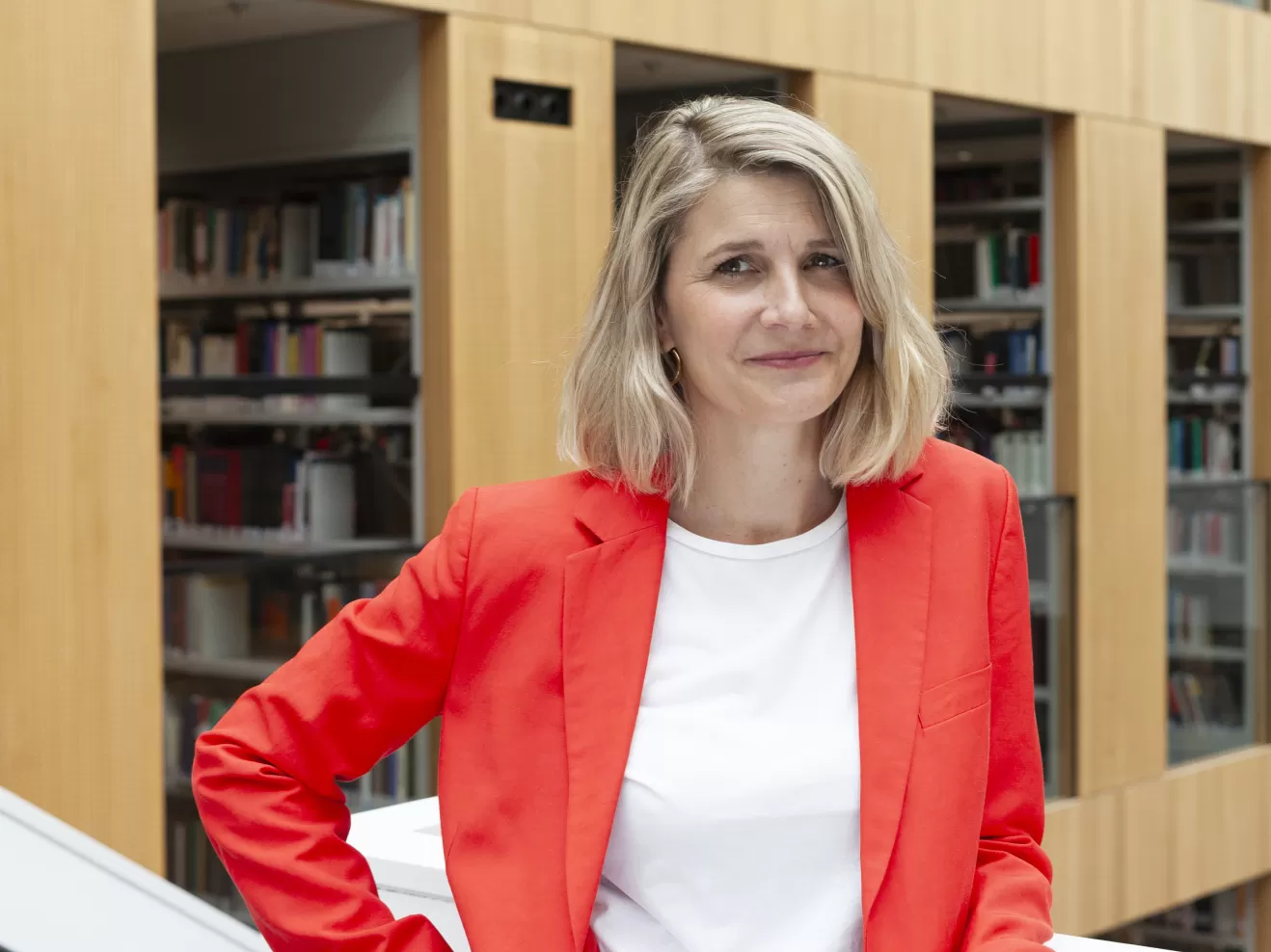 Portraitfoto von Anne Fleckstein vor einer Bibliothek