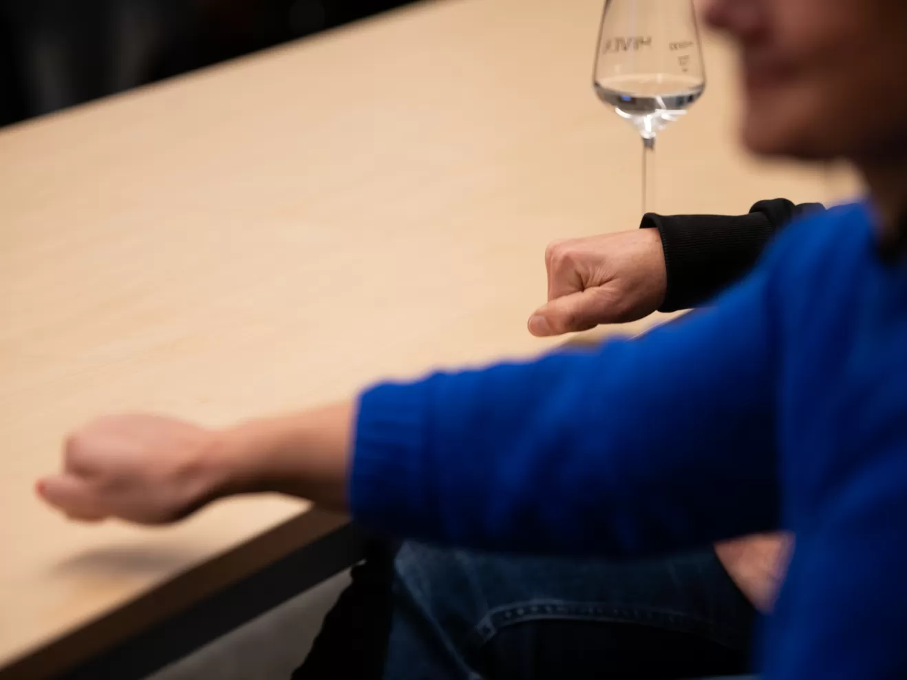 Zwei Personen sitzen an einem Konferenztisch, man sieht nur die Arme. Mit den Händen wird zustimmend auf die Tischplatte geklopft.