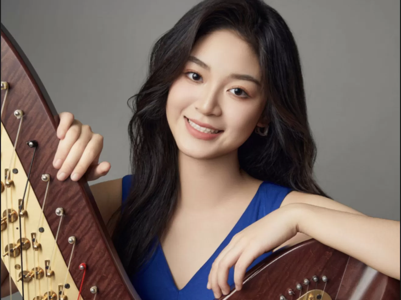 Portraitfoto von Liang Zhaotong mit Harfe