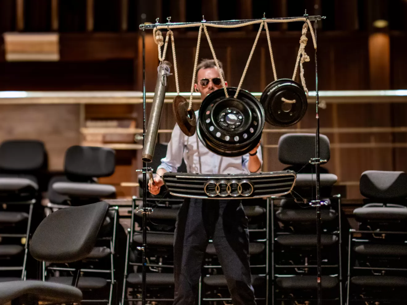 Ein Percussionist spielt auf Autoteilen.