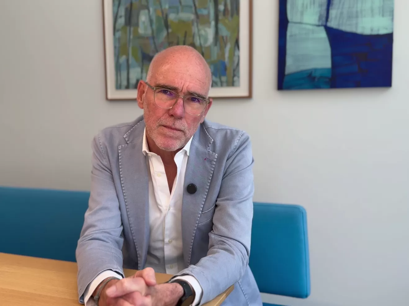 Prof. Fulda trägt ein helles Jackett und sitzt mit gefalteten Händen an einem Tisch, er blickt betroffen in die Kamera.