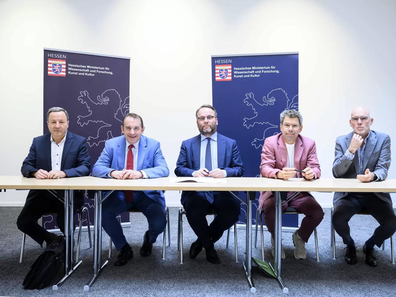 Fünf Herren am Tisch