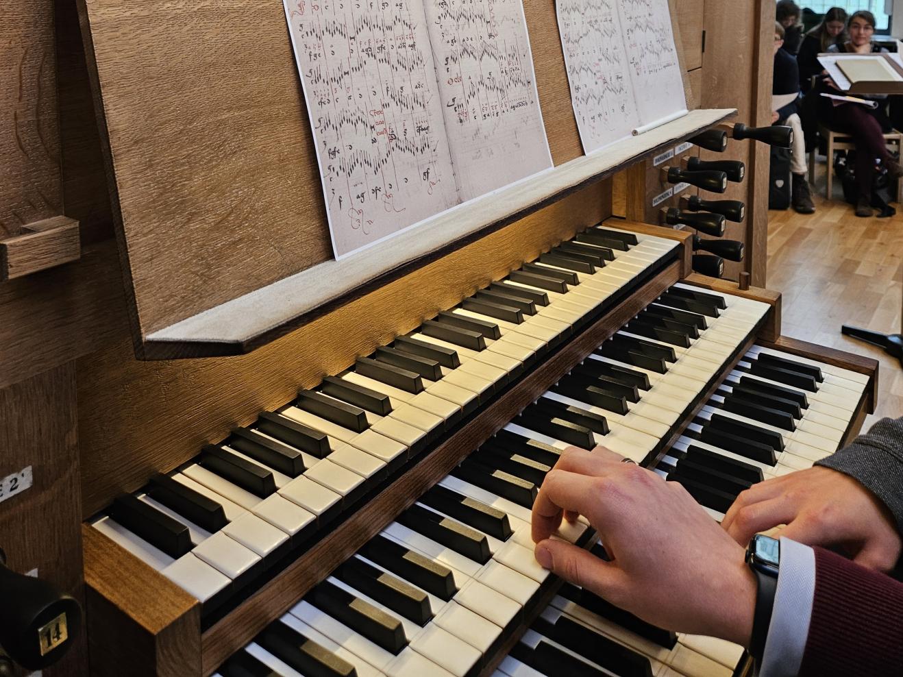 Workshop zu Orgeltabulaturen Nahaufnahme: Zwei Hände auf Orgeltasten, historische Noten auf Spieltisch