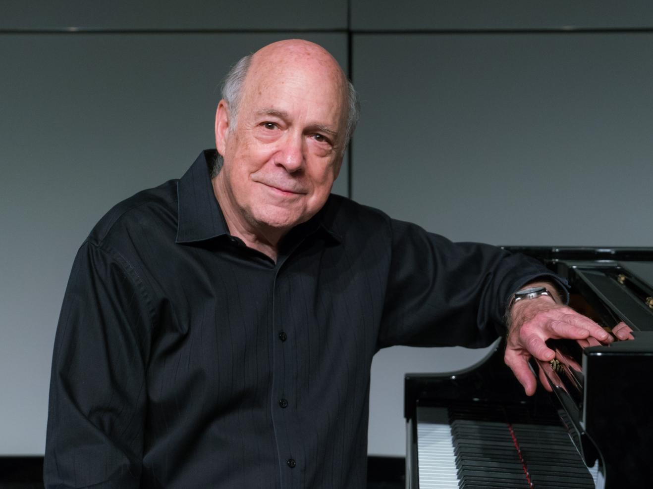 Porträtfoto von Victor Rosenbaum, der an einem Klavier sitzt.