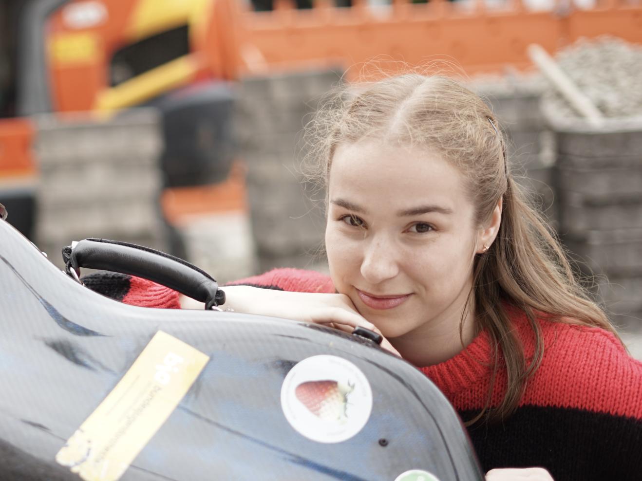 Porträt von Clara Stümke mit ihrem Instrumentenkasten