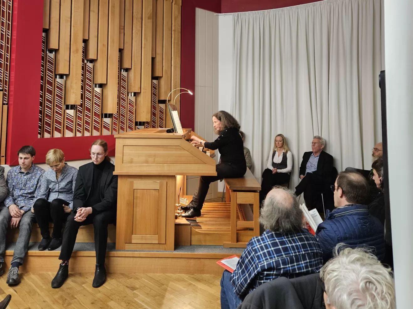 Kirsten Sturm spielt an der Orgel, der Raum voller Zuhörenden