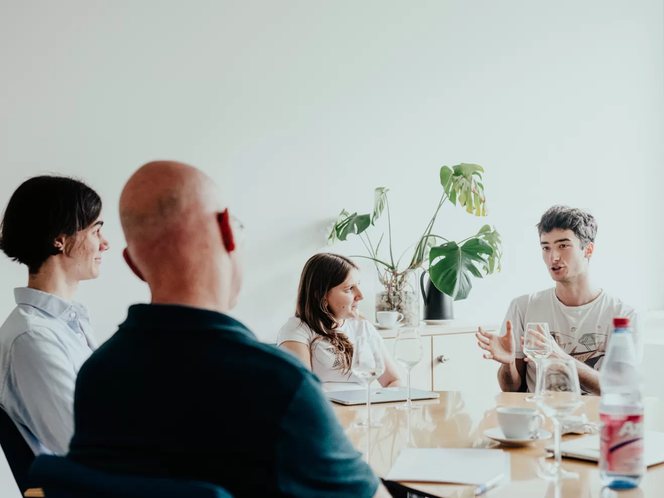 Drei Studierende sitzen mit dem Präsidenten am Tisch im Gespräch
